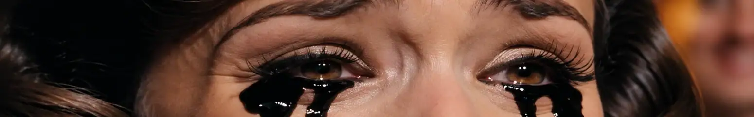 Black tears beneath a woman's eyes